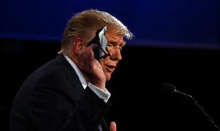 El presidente de Estados Unidos, Donald Trump, sostiene una máscara que tenía en el bolsillo durante el primer debate presidencial en Cleveland, Ohio, el 29 de septiembre. 