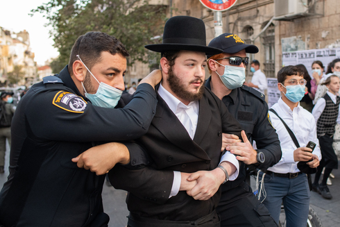 Un ultraortodoxo es detenido durante las protestas en Jerusalem contra el cierre general impuesto por el gobierno.