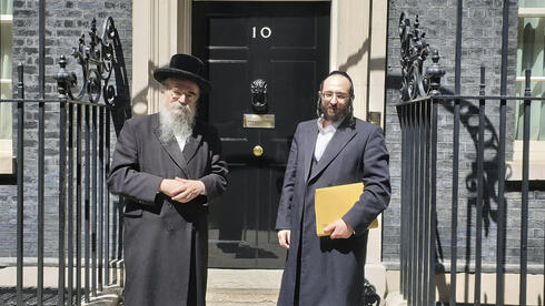 Avrohom Pinter com Joel Friedman da Fundação Interlink, uma organização que reúne instituições de caridade judaicas ortodoxas. (AP) Rabino de Londres