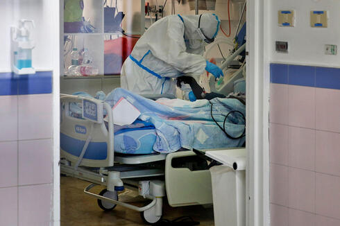 Trabajador de salud trata a paciente con coronavirus en el Centro Médico Barzilai en Ashkelon. 