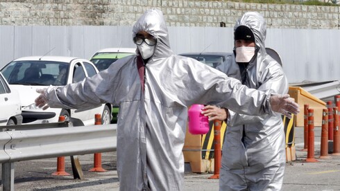 Un trabajador de la salud iraní desinfecta a un colega durante la propagación del virus en Irán.