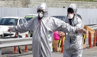 Un trabajador de la salud iraní desinfecta a un colega durante la propagación del virus en Irán.