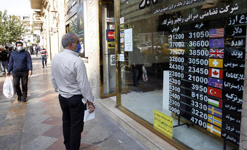 Un hombre de Irán observa las tasas de cambio en Teherán. 