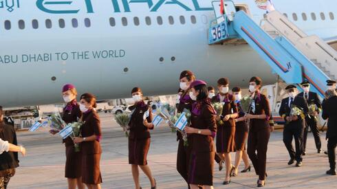 La tripulación del histórico vuelo desde Emiratos a Israel sosteniendo banderas israelíes.