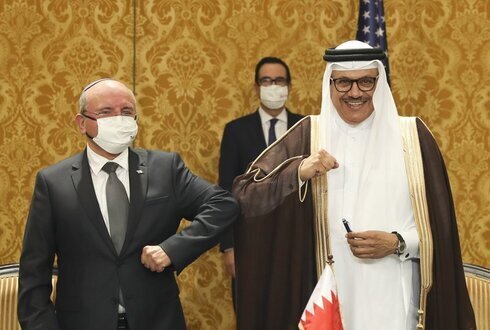 El jefe del Consejo de Seguridad Nacional de Israel, Meir Ben-Shabbat (izquierda), saluda con el codo al ministro de Relaciones Exteriores de Bahrein, Abdullatif al-Zayani, después de firmar un acuerdo en Manama. 