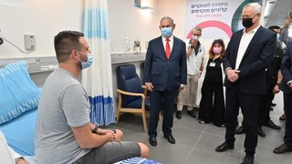 Benjamín Netanyahu y el ministro de Defensa, Benny Gantz, dialogan con Sagab Harel, el primer voluntario en recibir la vacuna israelí.