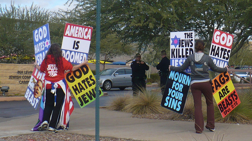 Manifestantes sostienen carteles que rezan "Dios odia a los judíos".