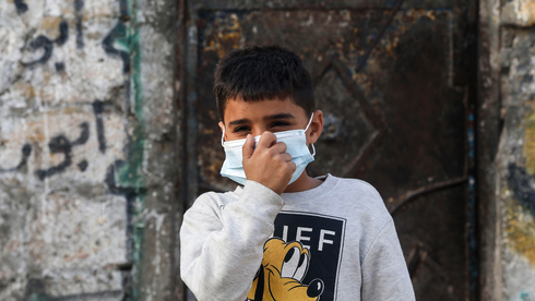 Un niño gazatí cubre su rostro con una máscara de protección.
