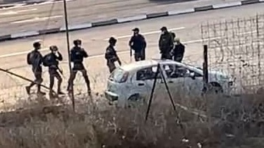 Combatientes israelíes junto al automóvil utilizado por el terrorista palestino.
