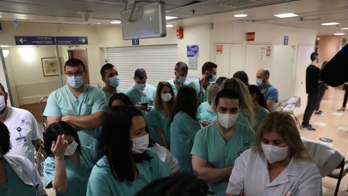 Membros da equipe médica do Ichilov Medical Center de Tel Aviv se alinham para receber a vacina COVID-19. (Moti Kimchi) Membros da equipe médica do Hospital Ichilov de Tel Aviv fazem fila para receber a vacina COVID-19.