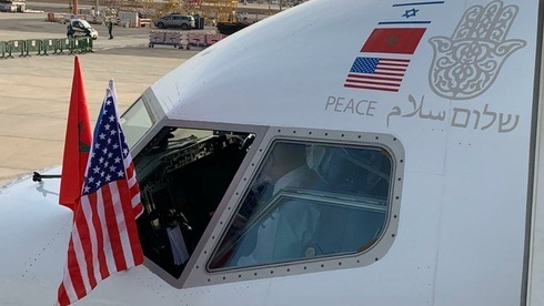 Las banderas de Israel, Marruecos y Estados Unidos junto a la palabra "paz" en hebreo, árabe e inglés en el avión que de El Al que partió hacia Marruecos.