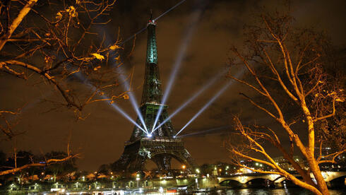 La Torre Eiffel de París se ilumina con colores y mensajes de esperanza en vísperas de la cumbre sobre el cambio climático de 2015.