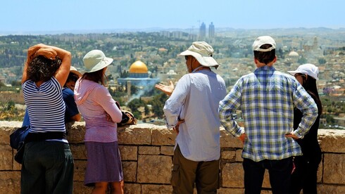 Um grupo de turistas e uma foto clássica de Jerusalém. (Shutterstock) reabrir o turismo
