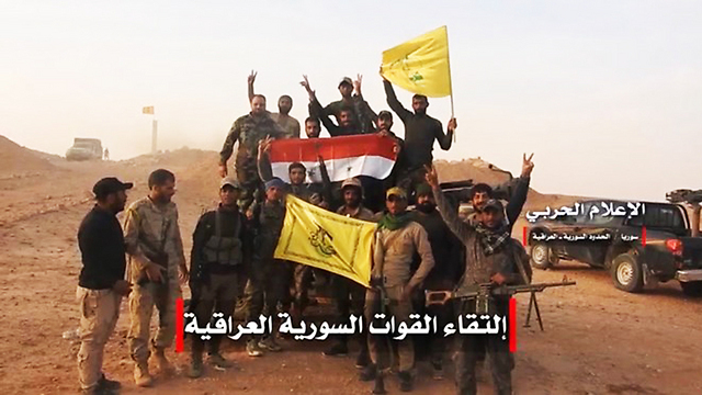 Milicias de Hezbollah, en Siria, portan banderas del país y de la organización terrorista. 