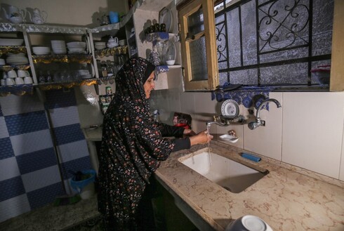 Uma mulher palestina lava as mãos com água da torneira na cidade de Khan Yunis, no sul da Faixa de Gaza. (AFP) água potável