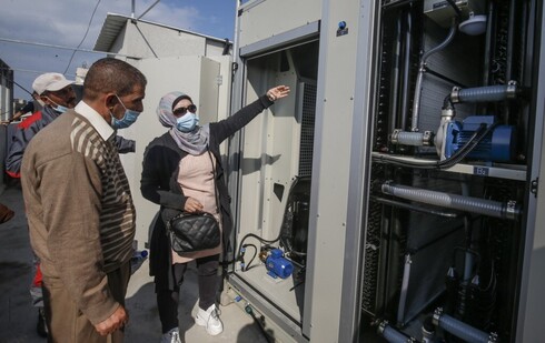 La ingeniera palestina Nadia Tubail revisa un generador de agua con energía solar. 