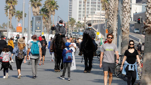 Israelíes caminan por la rambla de Tel Aviv mientras se encuentra vigente el tercer cierre general. 