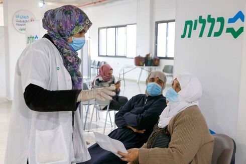 Una trabajadora de la salud habla con una mujer árabe israelí antes de darle la vacuna contra el COVID-19. 