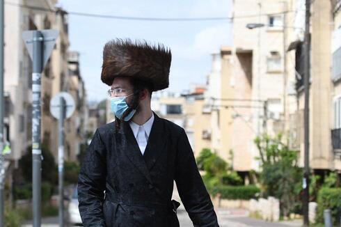 Un religioso ultraortodoxo, con barbijo, por las calles de Bnei Brak. 