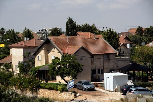 Una bandera israelí flamea cerca de un grupo de casas en el asentamiento de Otniel en Cisjordania. q