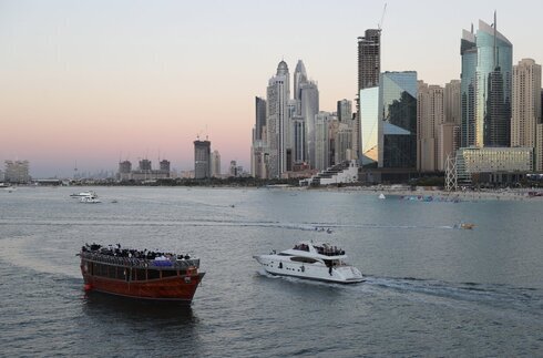A la izquierda, un crucero que vende a los turistas un show con cena; y a la derecha, otro yate con turistas, en Dubai. 