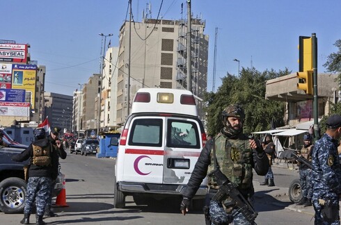 Una ambulancia y fuerzas de seguridad en el centro de Bagdad tras los ataques suicidas.