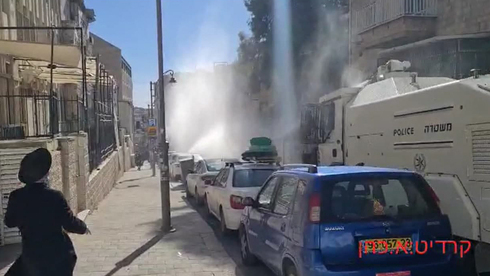 La policía dispersa a los manifestantes con un carro hidrante en Jerusalem.