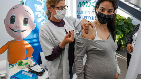 Una mujer embarazada se coloca la vacuna en Clalit. 