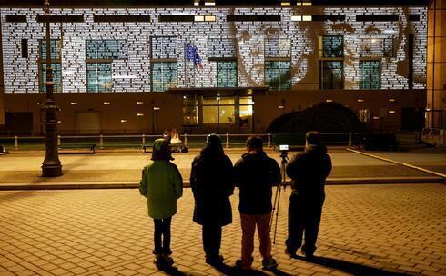 Personas observan una instalación de luces llamada #everynamecounts (cada nombre cuenta) que proyecta los nombres de las víctimas del régimen nazi en la fachada de la embajada francesa para recordar a las víctimas antes del Día Conmemorativo del Día Internacional de Conmemoración en Memoria de las Víctimas del Holocausto en Berlín, Alemania.