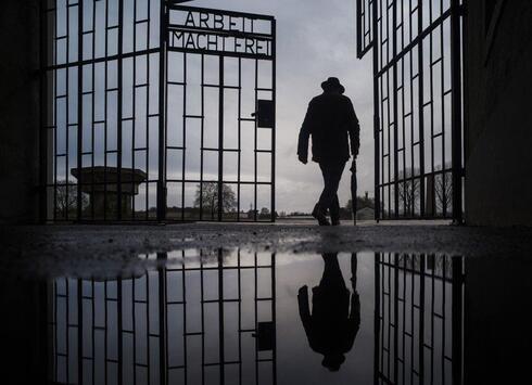 Un hombre cruza la puerta del campo de exterminio nazi de Sachsenhausen durante el Día Internacional de Conmemoración en Memoria de las Víctimas del Holocausto, en 2019. 