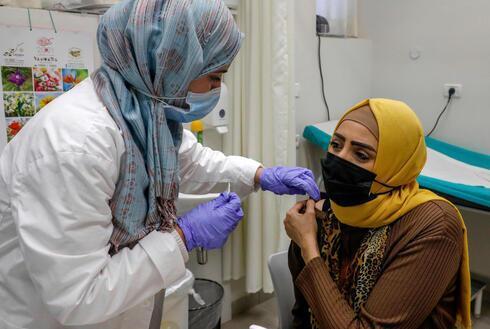 Una mujer palestina de Jerusalem Oriental es vacunada contra el coronavirus. 