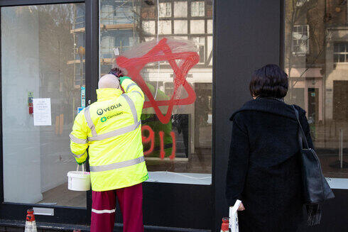 Preocupación en la Agencia Judía por el aumento del antisemitismo durante la pandemia. (MCT) Un trabajador municipal borra un graffiti antisemita en un comercio judío de Londres.