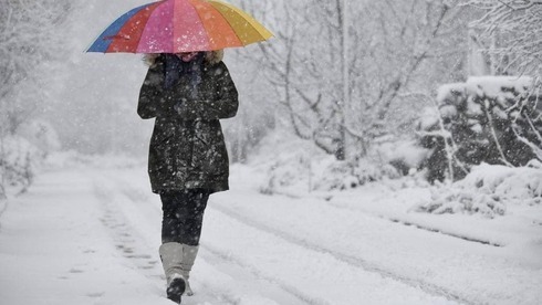 Una mujer camina bajo la tormenta de nieve en el kibbutz Merom Golan. 