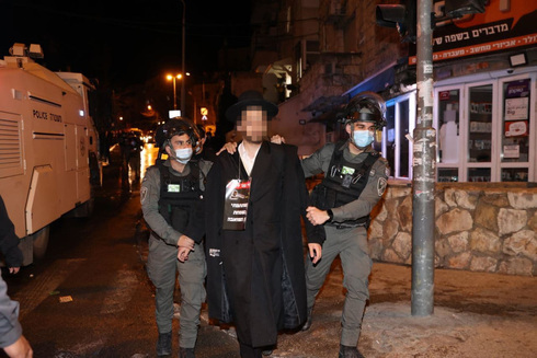 Agentes de policía arrestan a un hombre ultraortodoxo durante una protesta contra las restricciones del COVID-19 en Bnei Brak. (Alex Kolomoisky ) Agentes de policía arrestan a un hombre ultraortodoxo durante una protesta contra las restricciones del COVID-19 en Bnei Brak.
