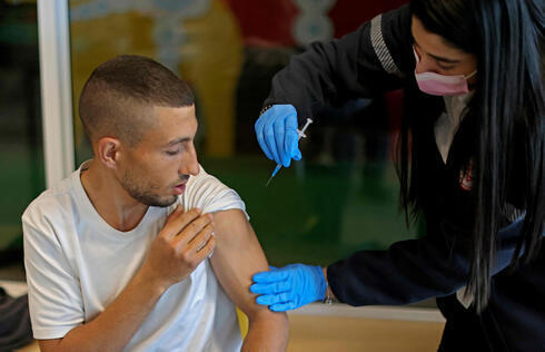 Una trabajadora de la salud aplica la vacuna a un joven en Beit Shemesh. 