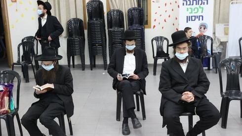 Judíos ortodoxos aguardan para ser vacunados contra el COVID-19. 