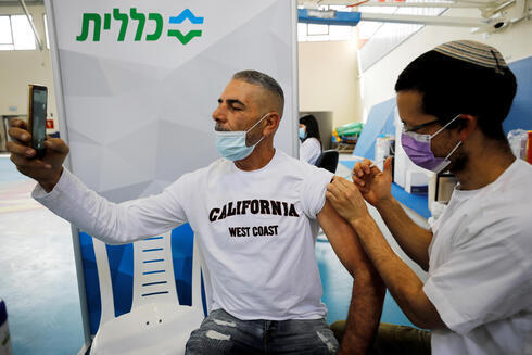 Un israelí se fotografía mientras recibe la vacuna en Netivot.