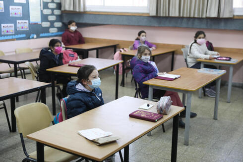Alumnos de una escuela primaria de Jerusalem asisten a una clase con mascarillas. 