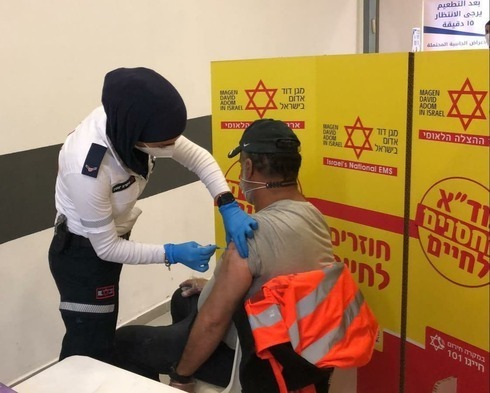 Uno de los trabajadores palestinos recibe su dosis de vacuna contra el coronavirus. 