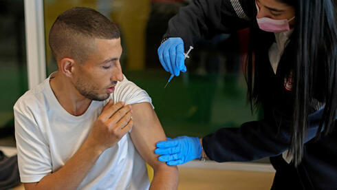 Um jovem recebe a vacina contra a COVID-19 em Beit Shemesh.Graves