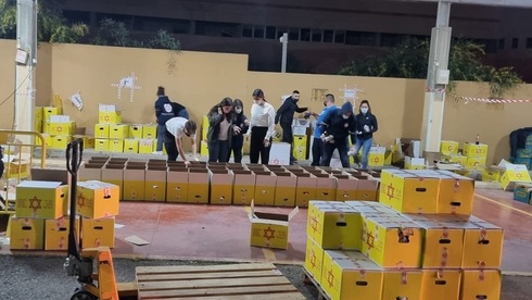 Voluntarios del Magen David Adom preparan cajas de alimentos para distribuir a familias necesitadas. (Magen David Adom) Voluntarios del Magen David Adom preparan cajas de alimentos para distribuir a familias necesitadas.