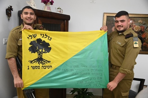 Amit y Or con la bandera firmada por el comandante de la brigada para Carmela Gibli. 