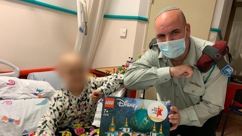 El coronel Maor Cohen entrega un kit de Lego a un niño con cáncer.