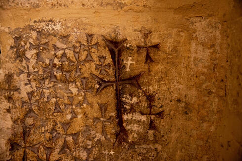 Las cruces grabadas en el antiguo muro de piedra de la capilla de Santa Elena en la Iglesia del Santo Sepulcro en Jerusalem. 