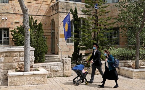 Famiila judía ortodoxa camina por el frente de la embajada de Kosovo en Jerusalem. 
