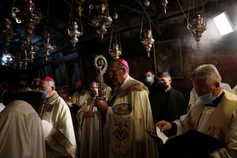 El Patriarca Latino de Jerusalem, Pierbattista Pizzaballa, dirige una misa de medianoche de Navidad en la Iglesia de la Natividad en Belén, Cisjordania. 