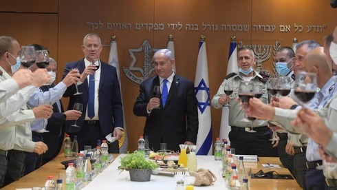 El primer ministro Benjamín Netanyahu (centro), el ministro de Defensa Benny Gantz (izquierda) y el jefe de Estado Mayor del Ejército, Aviv Kochavi, brindan junto a altos funcionarios de seguridad. 