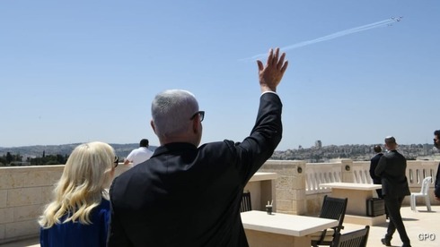 Netanyahu y su esposa saludan el paso de los aviones. 