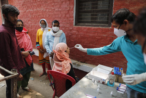 Un trabajador de la salud realiza una prueba de coronavirus en la ciudad de Prayagraj, en el norte de India.