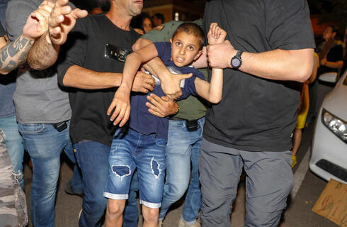 Policías de civil detienen a un niño árabe durante las manifestaciones. 